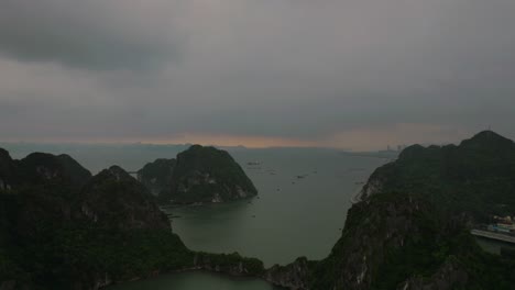 Drone view of Ha Long Bay, Vietnam, capturing the stunning sea and rocky formations at sunset, creating a breathtaking and serene atmosphere.