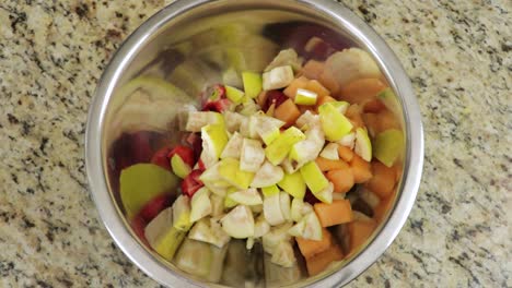 Overhead-view-of-adding-Chopped-fruit-in-a-bowl