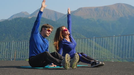 couple stretching outdoors in mountain scenery