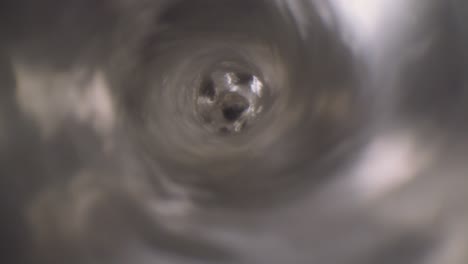 vórtice de agua disparado bajo el agua macro extrema primer plano de un agujero de tapón de fregadero de lavandería mientras el agua se vacía con un gran vórtice que se forma alrededor de la lente