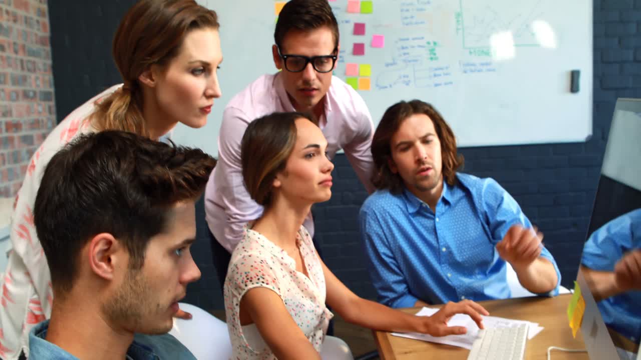 hombre de negocios interactuando con un compañero de trabajo mientras usa la computadora