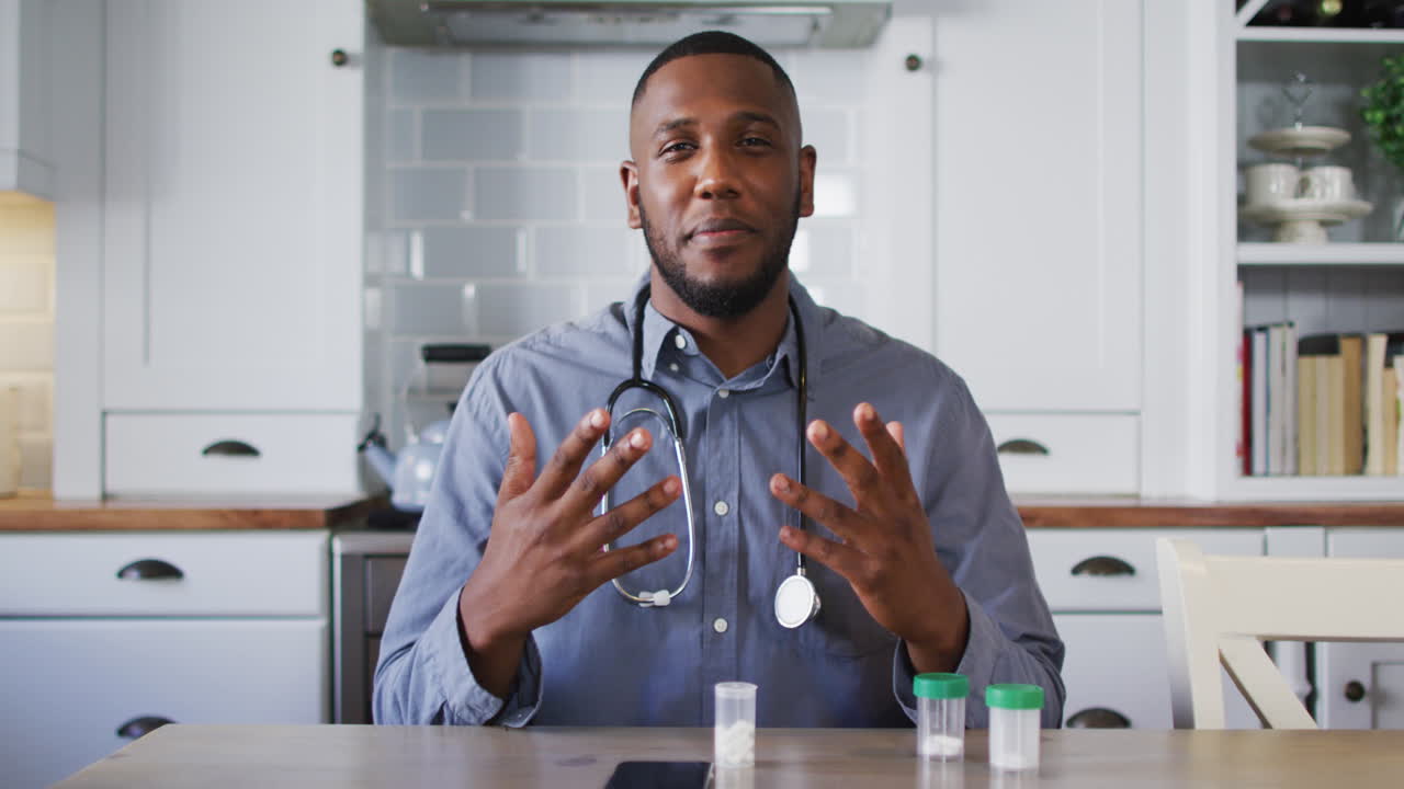 Portrait of african american doctor talking while having a video call at home