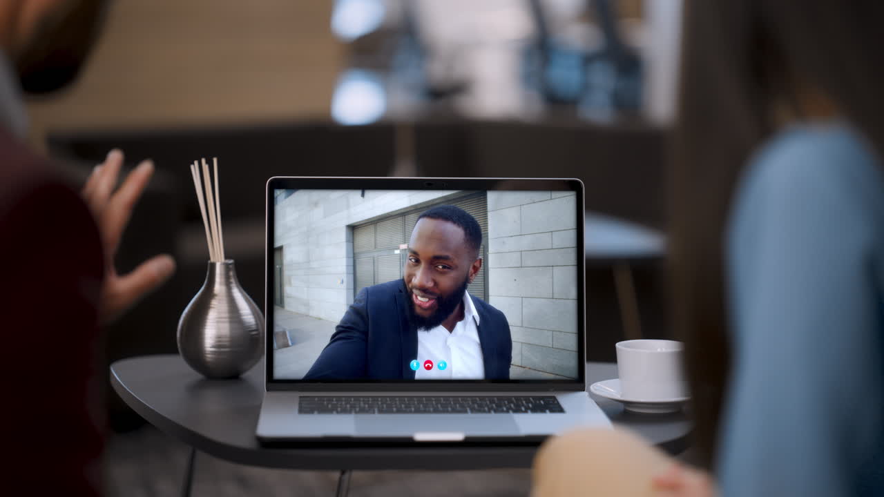Corporate people talking virtual meeting using laptop webcam restaurant close up