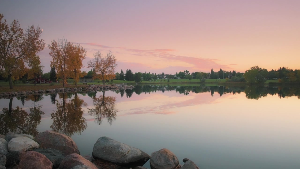 Riflesso di alberi autunnali nel lago al tramonto