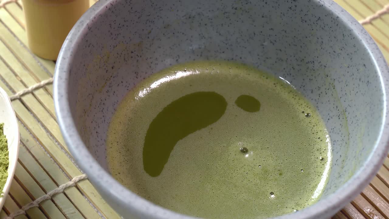 juego de matcha en polvo, tazón, batidor de bambú y té verde matcha preparado en la mesa