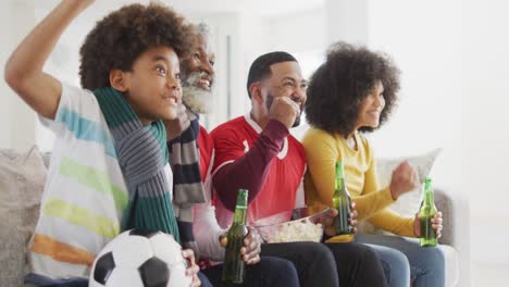 multi-generation family cheering while watching sports on tv at home