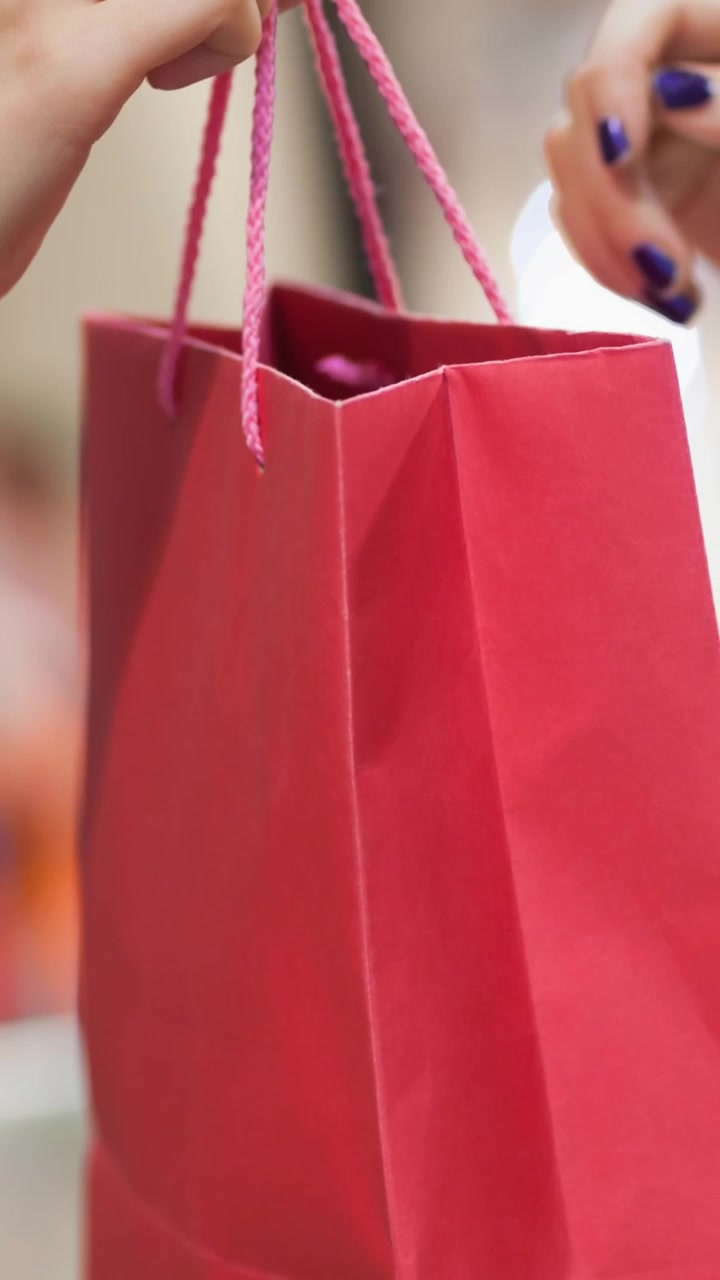Parte central de dos mujeres caucásicas con una bolsa de compras.