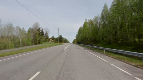 Cars-traverse-along-the-road-while-trees-line-the-sides,-creating-a-pleasant-and-scenic-drive-amidst-the-natural-surroundings