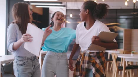 multiethnic students having fun chatting in school talking and laughing together.