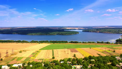 stunning view of the wheat fields, river and forests on sunny summer day. beautiful blue skies with rare clouds at backdrop.