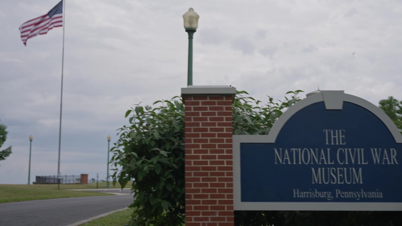 Panoramica cinematografica sull'insegna del Museo Nazionale della Guerra Civile e sulla bandiera americana a Harrisburg, Pennsylvania, che evidenzia la storia della Guerra Civile, il patriottismo e il patrimonio culturale