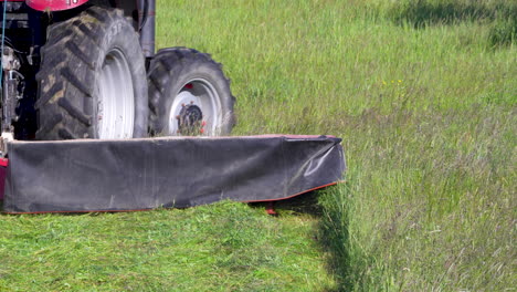tractor mowing grass on airfield at, preparing runway surroundings