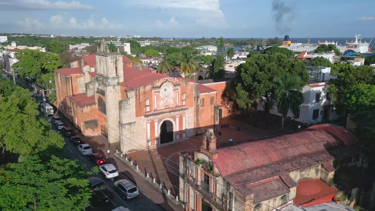 fotografía de órbita aérea que muestra la antigua iglesia y convento de los dominicos en santo domingo al atardecer - coches conduciendo por la carretera
