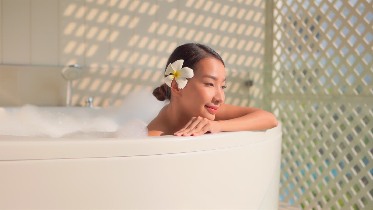 A close up of pretty young Asian woman in a bubble bath
