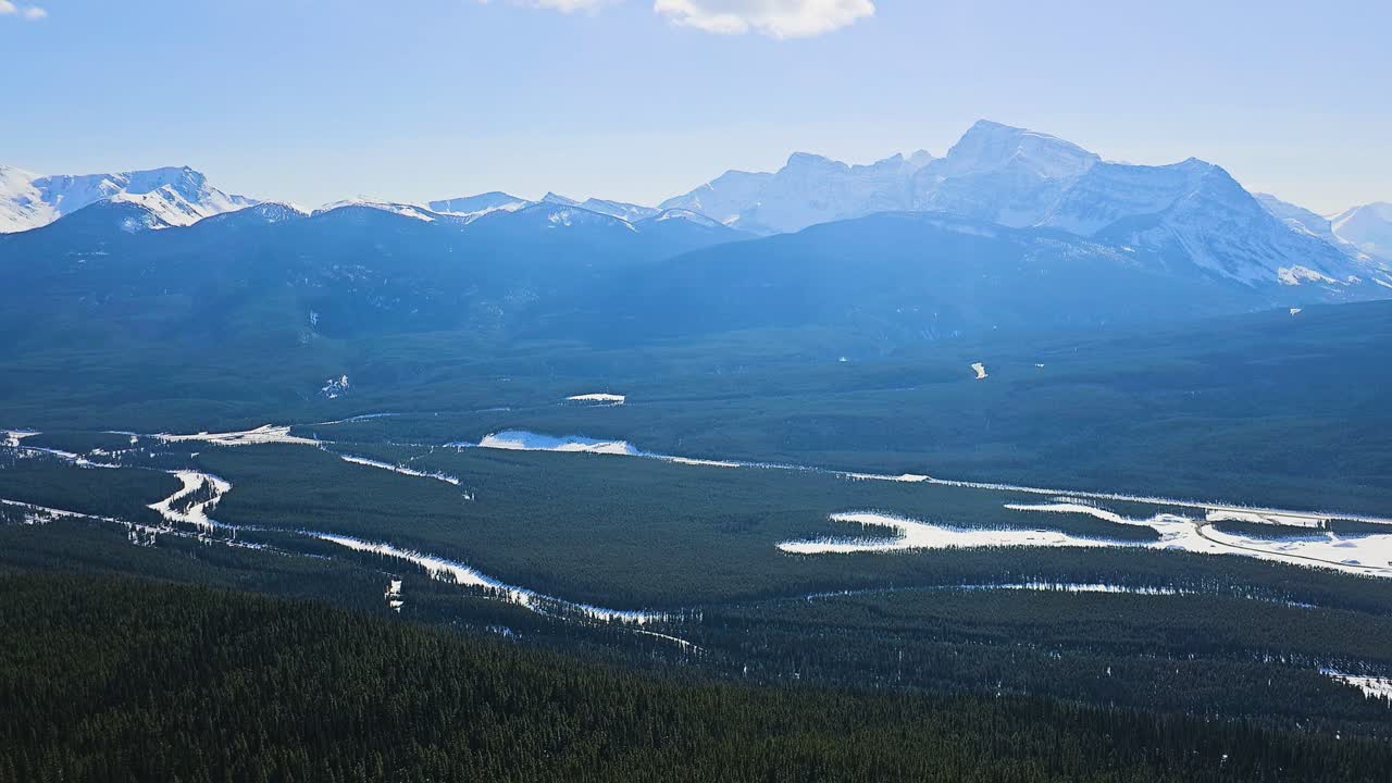 Forhøjet vildmarksudsigt i Jasper-stil afslører udstrakt stedsegrøn skov, snoet vand og barske alpetoppe, der fanger omfanget og skønheden af de canadiske Rocky Mountains.