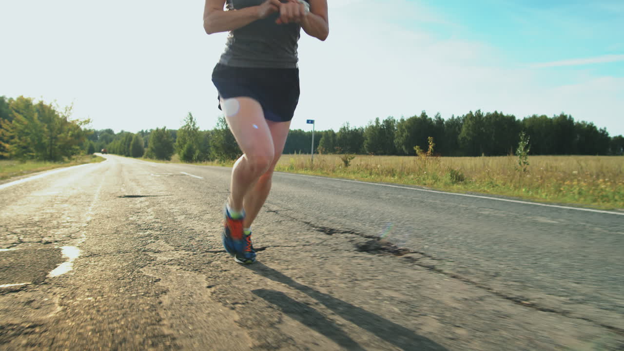 triatleta femenina corriendo en la carretera