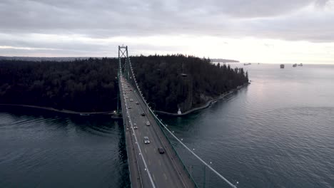 cars driving along famous lions gate bridge, vancouver in canada