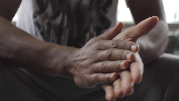 Athlète masculin noir se frottant les mains avant un entraînement ou un match, gros plan.