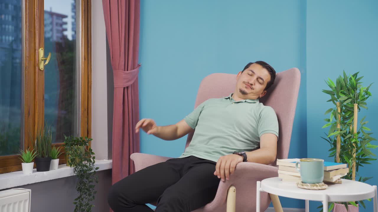 소파에 누워 있는 남자가 휴식을 취하고 있습니다.