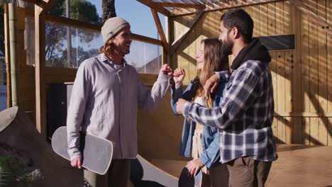 video of happy diverse female and male skateboarders in skate park