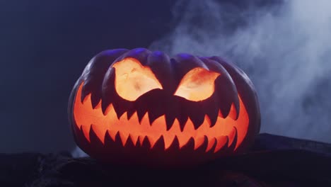 Video-of-halloween-carved-pumpkin-with-smoke-on-black-background