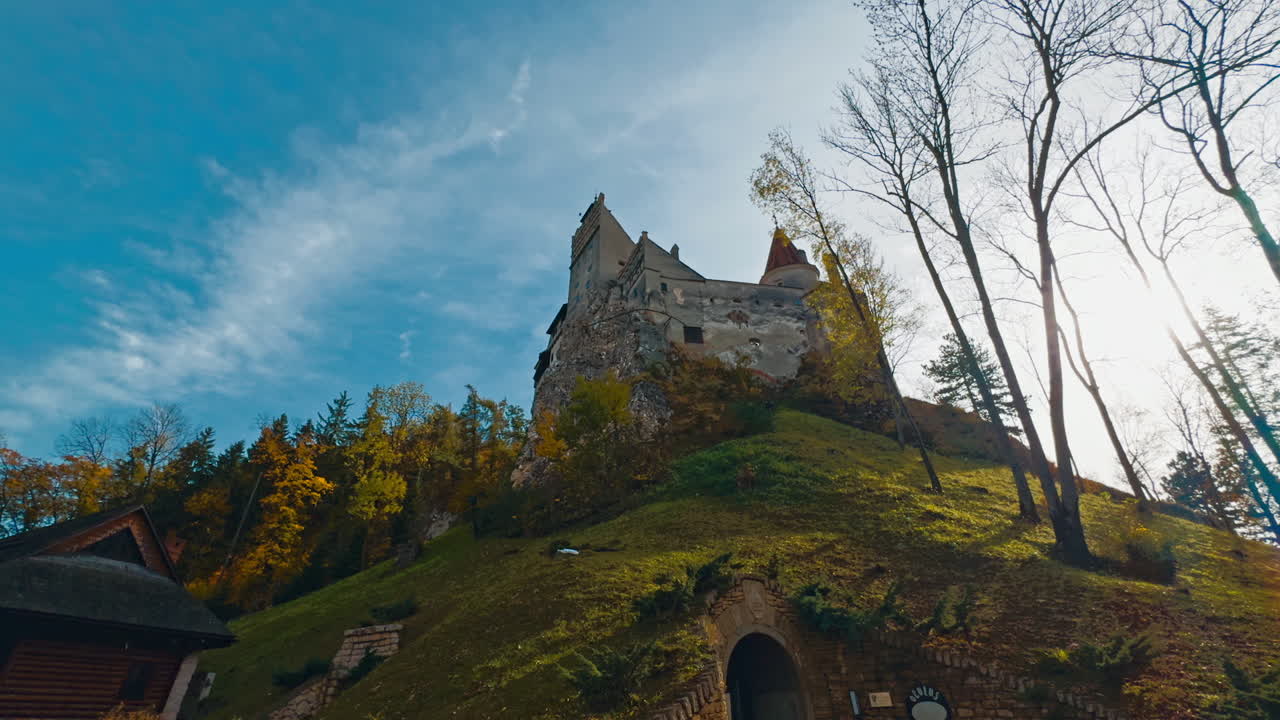 Secret entrance to the castle standing on the high hill. Low angle view on Bran Castle in colorful autumn season.