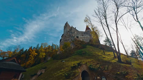 secret entrance to the castle standing on the high hill. low angle view on bran castle in colorful autumn season.