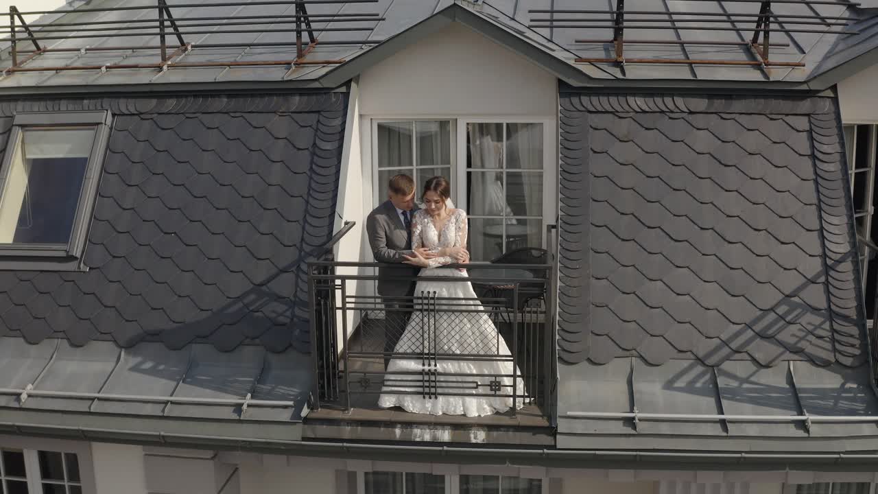 recién casados caucásicos novia abrazando al novio en el balcón de la habitación del hotel, vista aérea