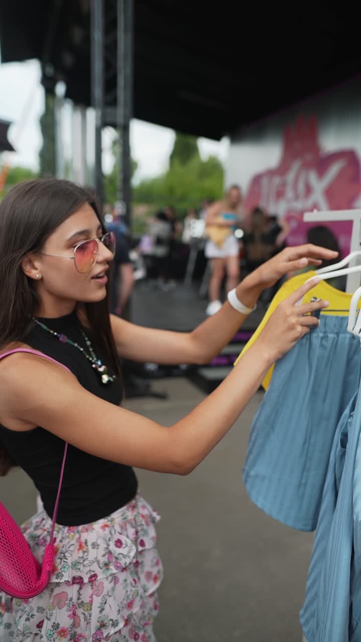 Giovane donna che fa shopping di vestiti a un festival