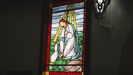 stained glass art of praying figure - jesus and the lamb