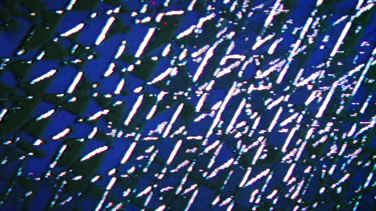 Pulsing waves of motion spread across video synthesizer feedback pattern.