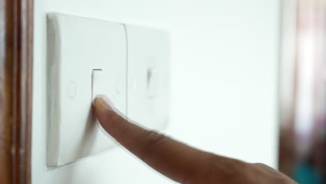 persona que enciende o apaga un interruptor de luz