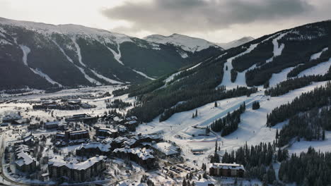 disparo de inclinación hacia atrás de un dron de un pueblo de deportes de invierno en la montaña de cobre en invierno