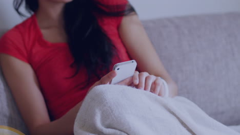 집의 소파에서 스마트폰을 사용하는 아시아 여성에 대해 떠다니는 쇼핑 카트 아이콘