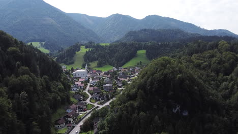 Picturesque-Austrian-mountain-village-with-a-church,-drone-flight