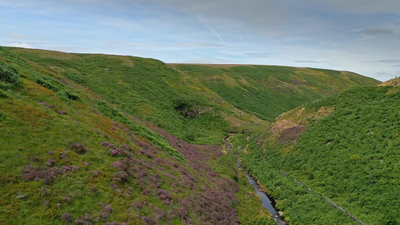 imágenes aéreas de drones de un río de páramos que fluye por un valle verde cerca de pennine way en marsden west yorkshire
