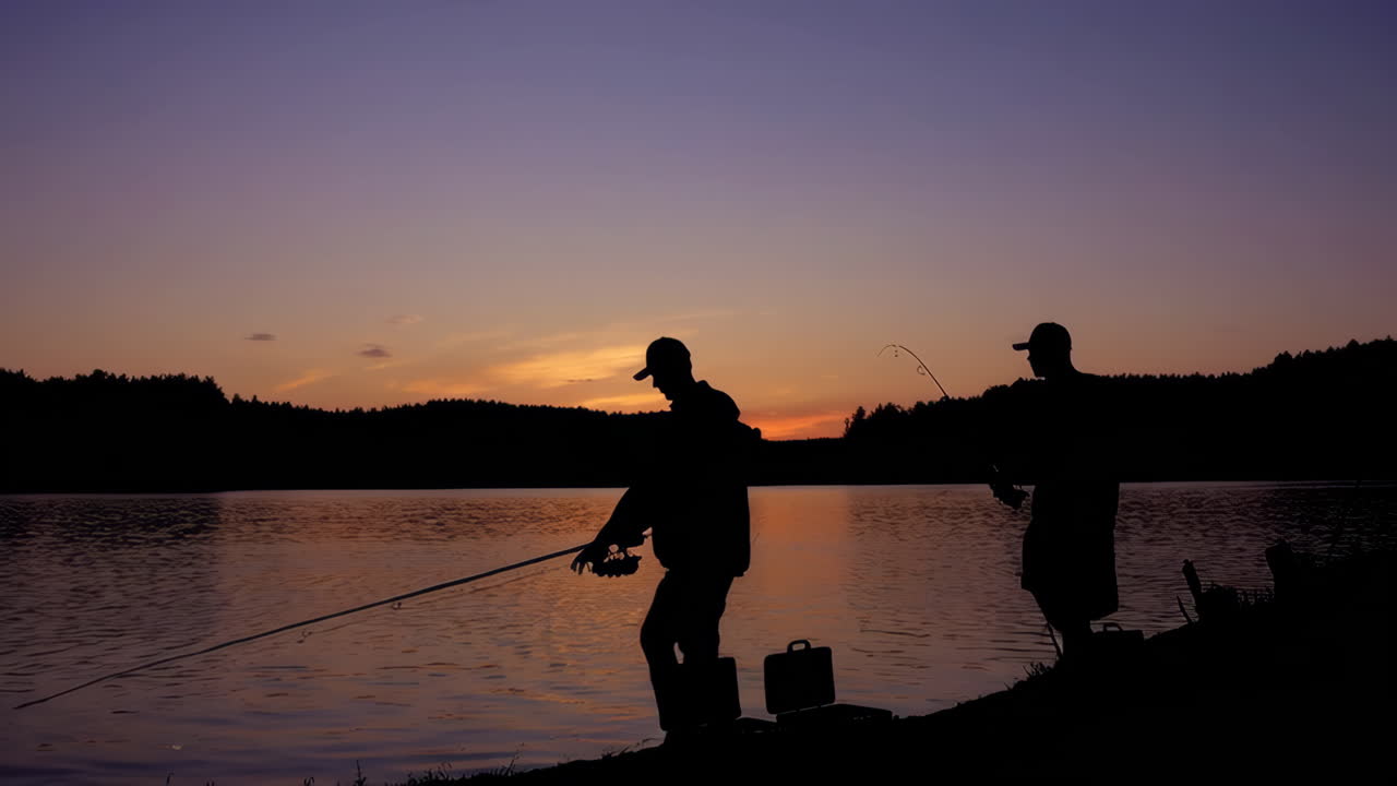 Siluet Pria-pria Memancing Saat Matahari Terbenam di Danau