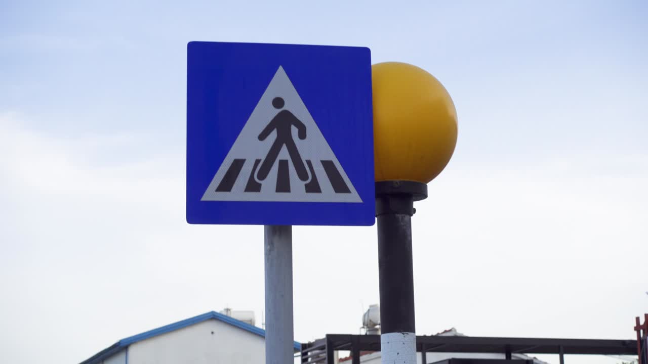 señal de cruce de peatones no regulada contra el cielo azul del atardecer. semáforo redondo amarillo parpadeando