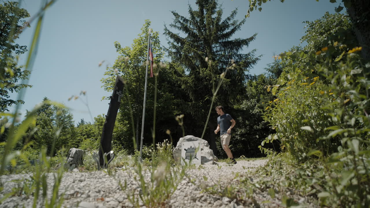 한 주자가 숲에서 공터로 달려가 멈춰 서서 뒷주머니에서 소책자를 꺼내서 펼쳤습니다.