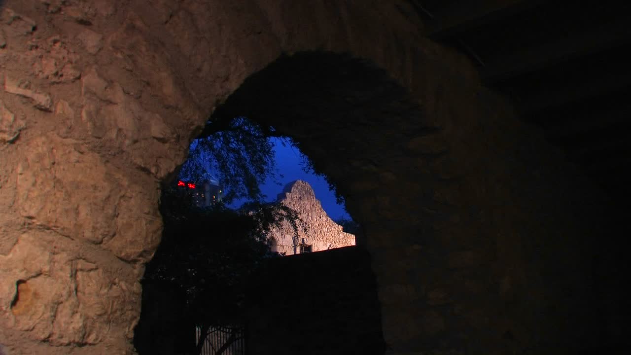 샌안토니오 텍사스 1의 벽돌 아치형 통로를 통해 돌담이 보입니다.