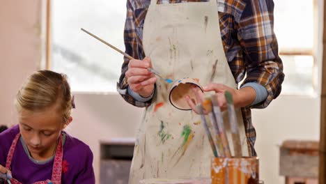 mother and daughter painting a bowl