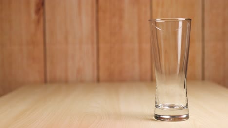 red liquid fills a clear glass gradually