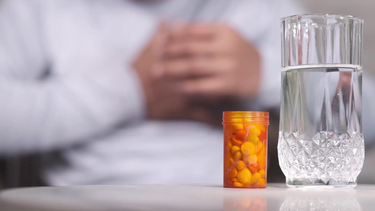 가 통증이있는 사람은 약물과 물을 먹고 있습니다.