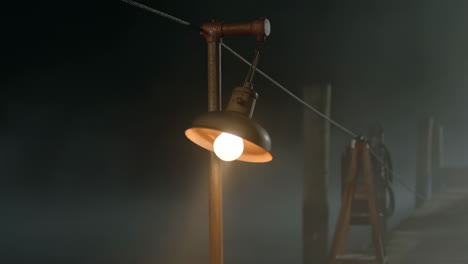 old lamp on a foggy dock at night