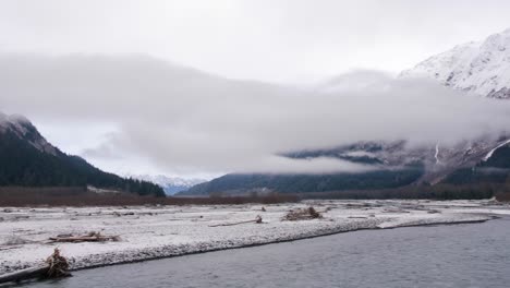 la niebla yace sobre un río en un valle de montaña en alaska