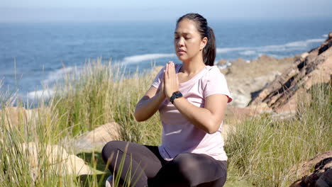 practicing yoga near ocean, woman meditating outdoors and enjoying nature