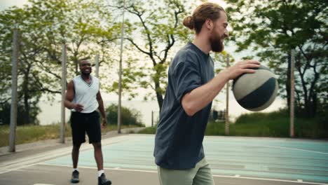 un hombre de espalda con una camiseta blanca y un hombre de pelo rojo con una camiseta gris están jugando al baloncesto. el hombre negro supera a su oponente y anota un gol brillante en un juego de baloncesto