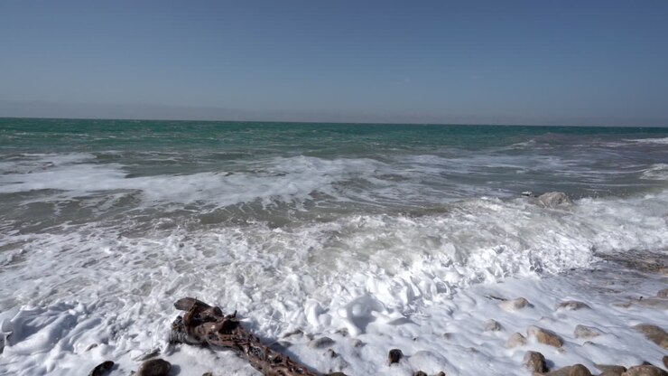Grandi onde del Mar Morto che si infrangono sulla costa in una splendida giornata di sole al rallentatore