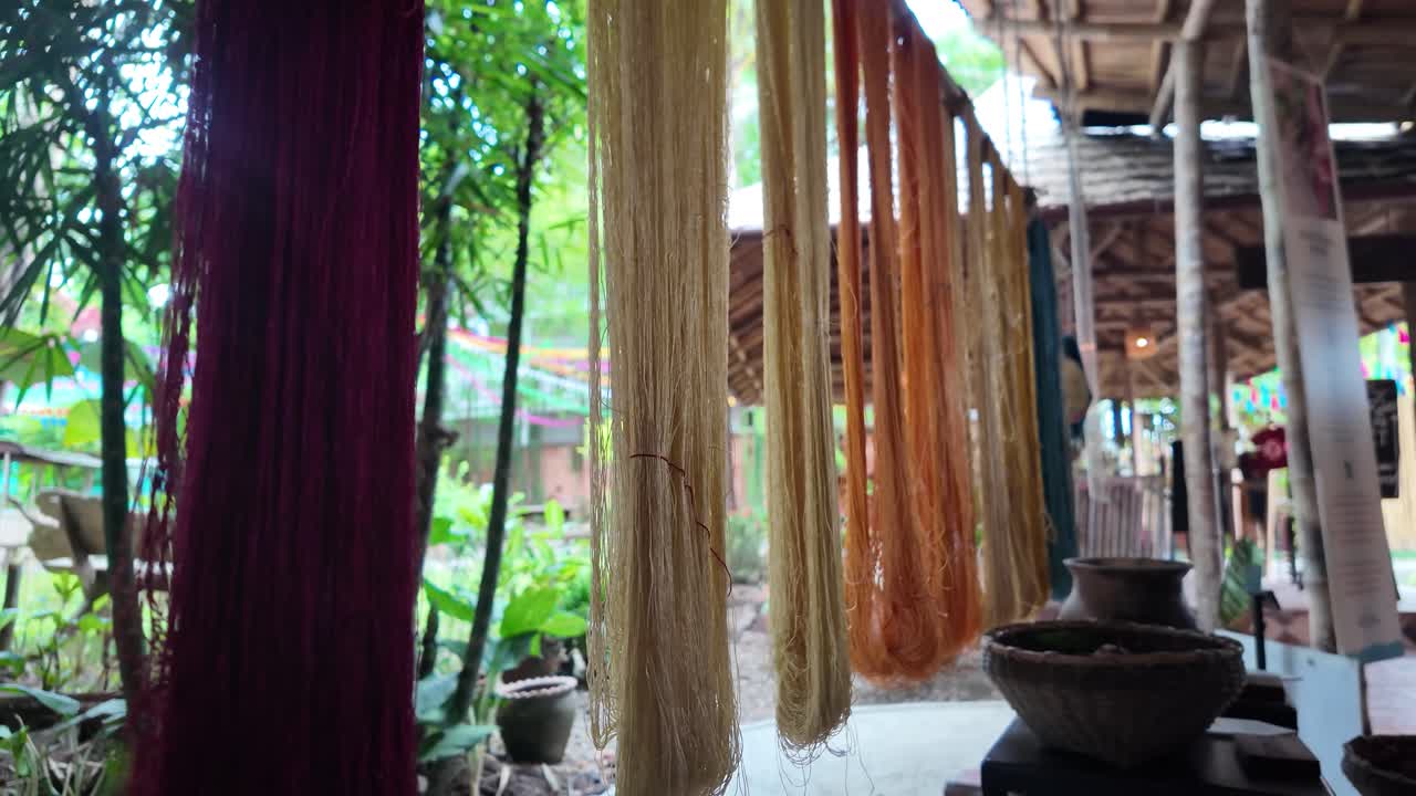 Benang sutra warna-warni yang dikeringkan setelah pewarnaan alami, bagian dari tenun tradisional di Laos