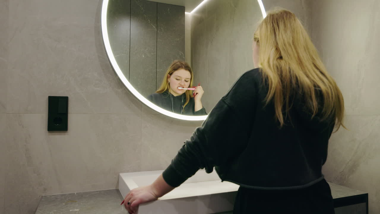 Donna che si lava i denti in un bagno moderno